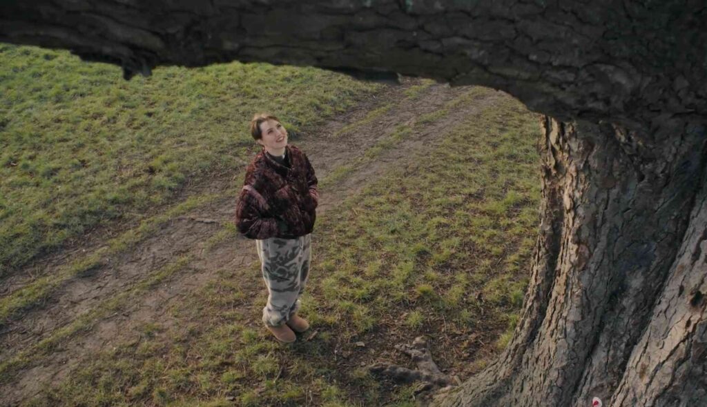 Chica joven habla con un árbol