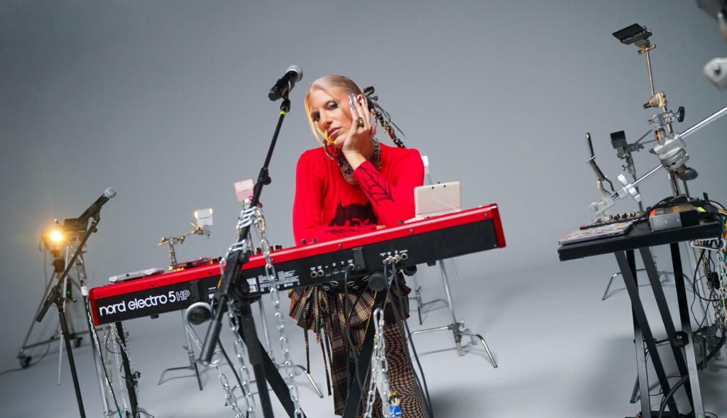 La artista Ganges posando con un piano electrónico