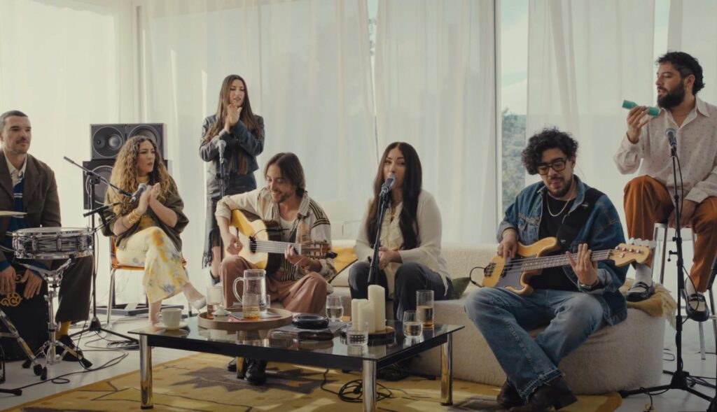 Grupo de músicos interpretando una canción en un salón.