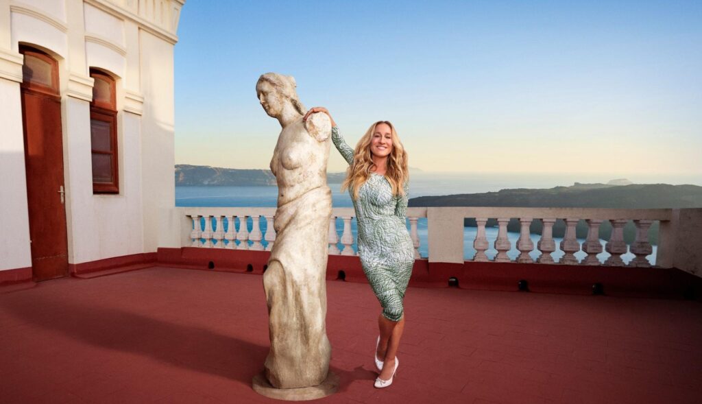 Sarah Jessica Parker posando en una gran terraza junto a una escultura griega o romana