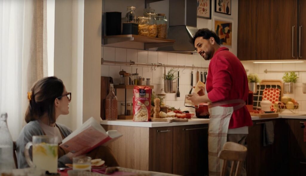 Hombre cocinando pasta Gallo para una mujer en una cocina