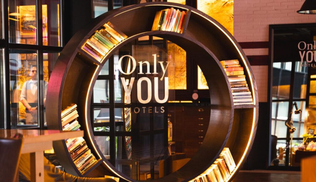 estantería de Only You Hotels, con forma circular y luces led integradas, en un espacio común de uno de sus hoteles.