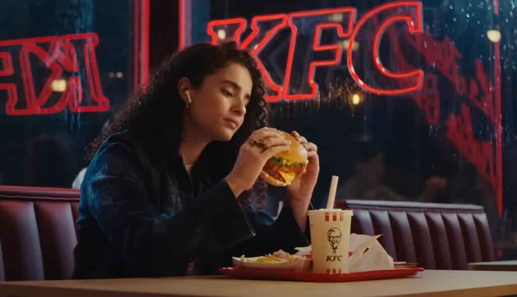 Chica comiendo una hamburguesa en un restaurante KFC