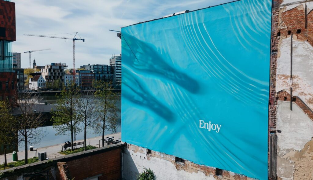Cartel publicitario de Coca-Cola en la campaña "Shadows", que muestra una piscina con la sombra de dos botellas de la marca.