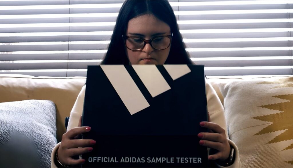 Persona con síndrome de Down abriendo una caja de Adidas