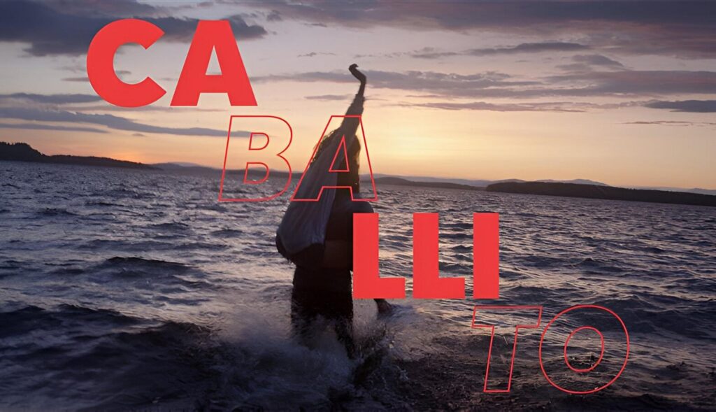 Una persona subida encima de otra en una playa al atardecer