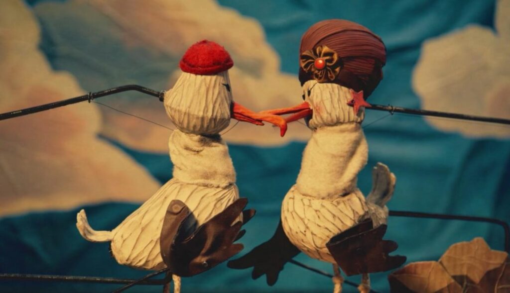 Dos albatros creados con marionetas mirándose entre sí antes de separarse.
