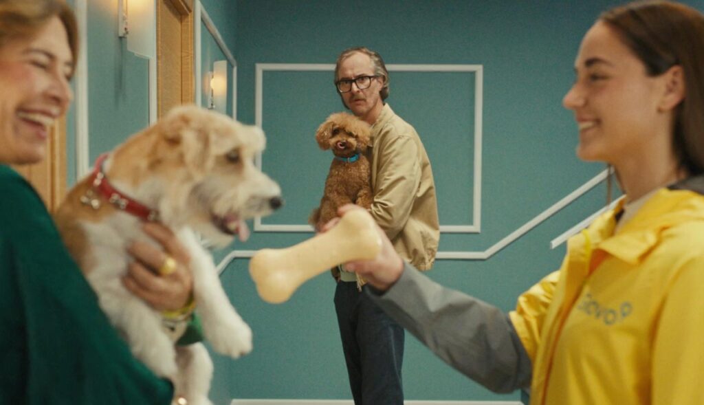 Vecinos con perros en el rellano de una casa, en el anuncio de Glovo