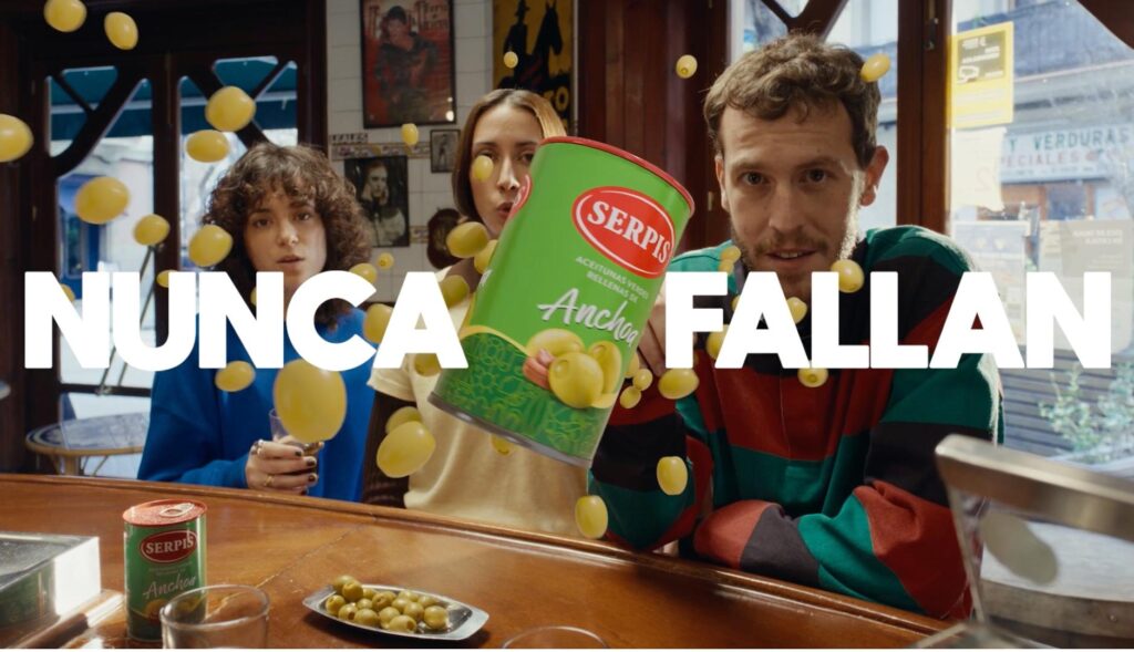 tres amigos en un bar tras el bote de aceitunas serpis