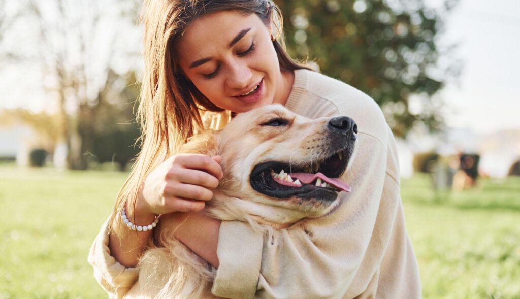 Chica joven abraza a su perro en un parque