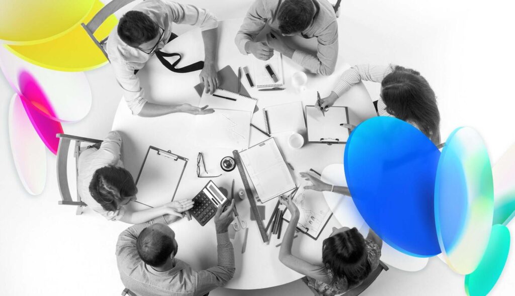 un plano cenital con personas trabajando sentadas en una mesa