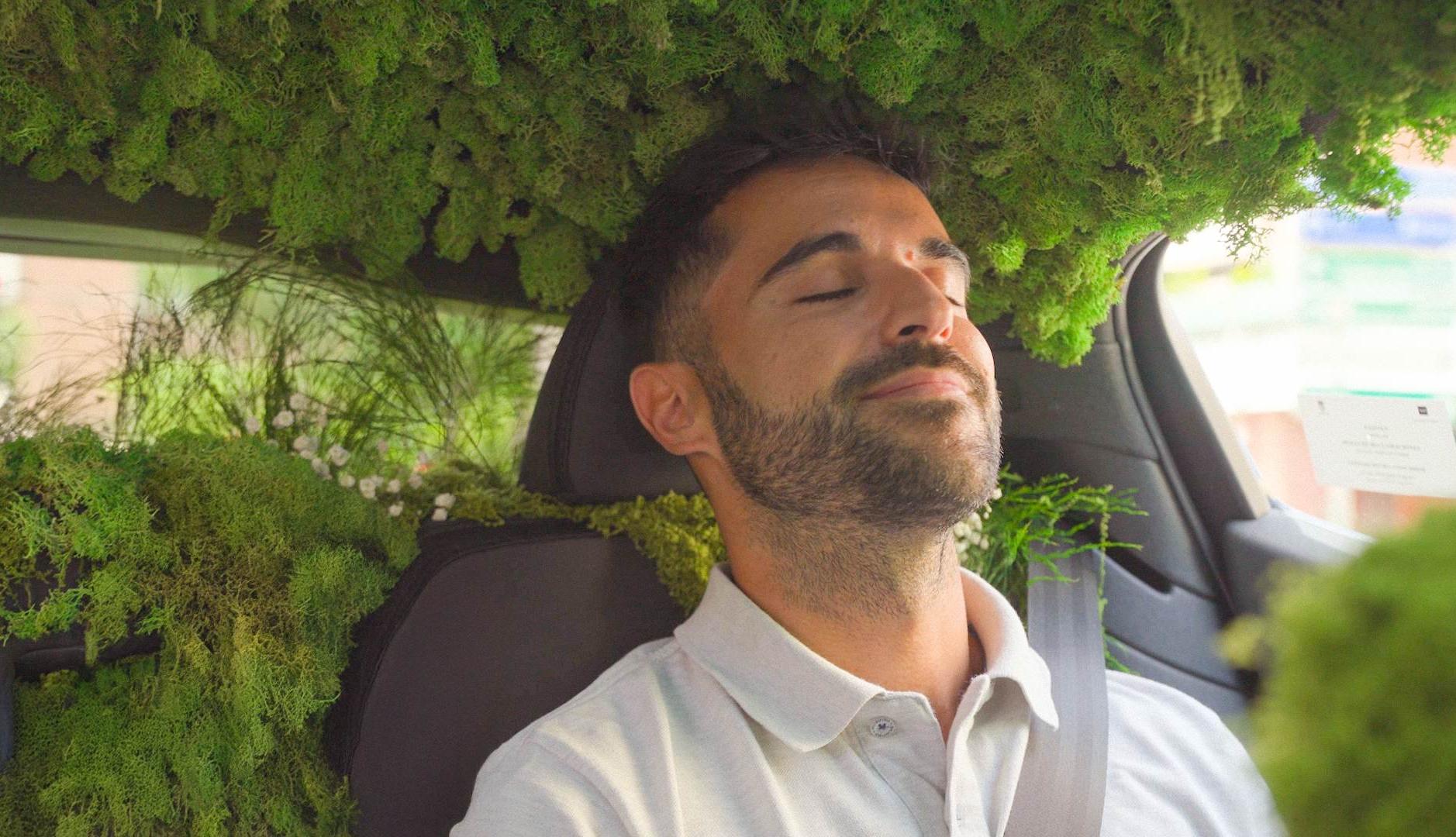 Chico dentro de un coche adornado como un bosque