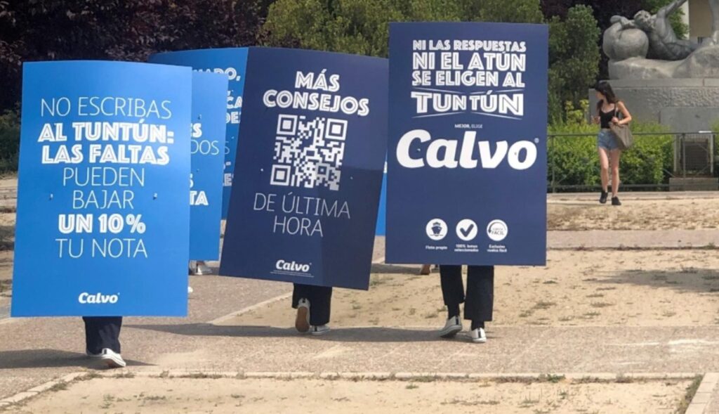 los carteles de los hombres anuncio paseando por la entrada de la universidad complutense de Madrid