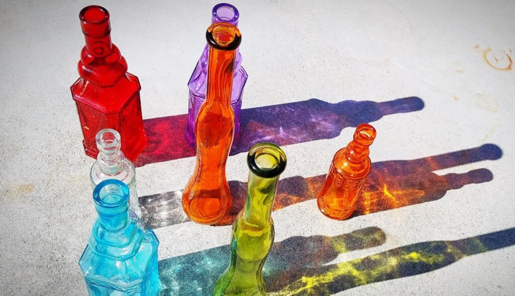 botellas de cristal de colores generando sombras