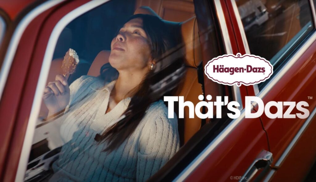 Una chica se come un helado Häagen-Dazs en un coche
