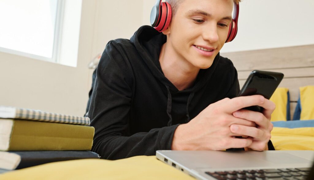 Chico utilizando móvil y ordenador