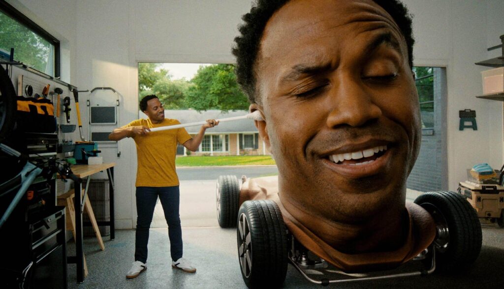 Un hombre limpia los oidos a una cabeza gigante