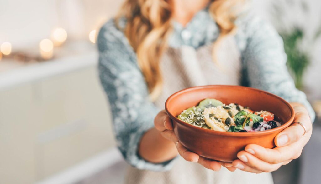 Chica suejta un bol con comida
