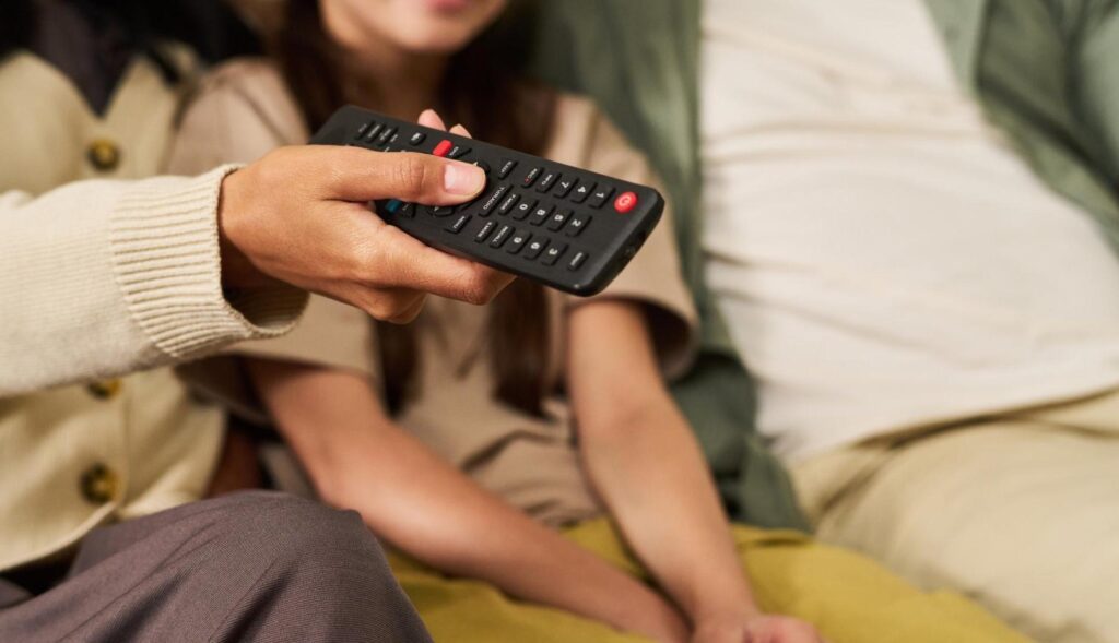 Mujer sujeta un mando de televisión