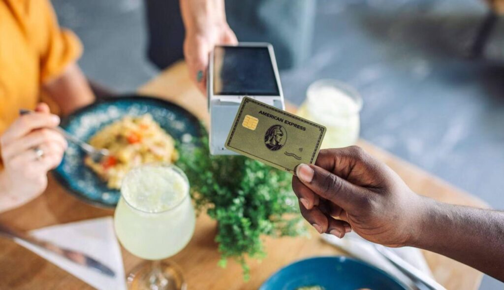 Persona pagando en un datáfono con una tarjeta de American Express