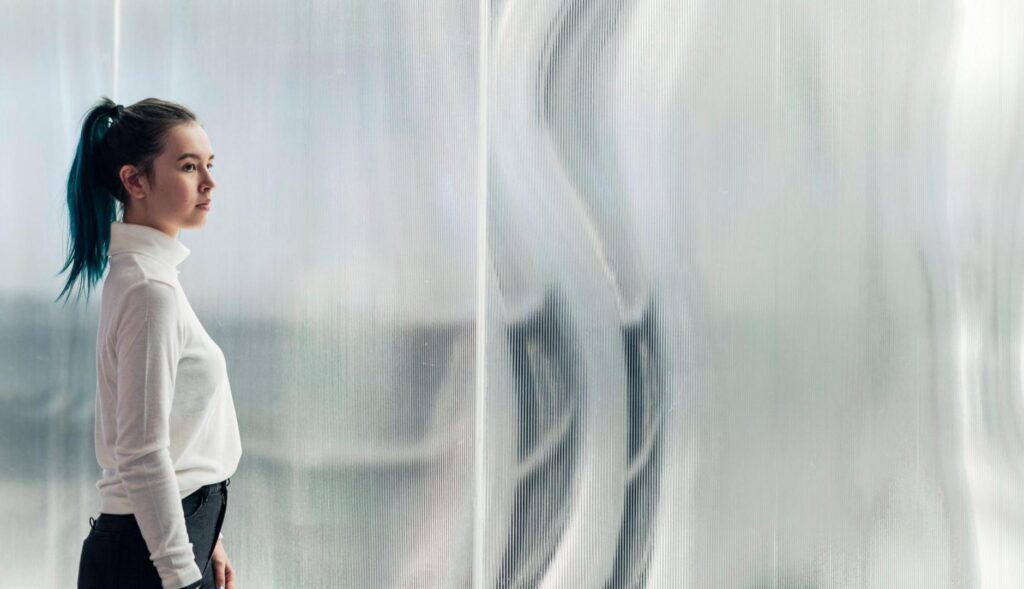 Chica frente a panel vidrioso
