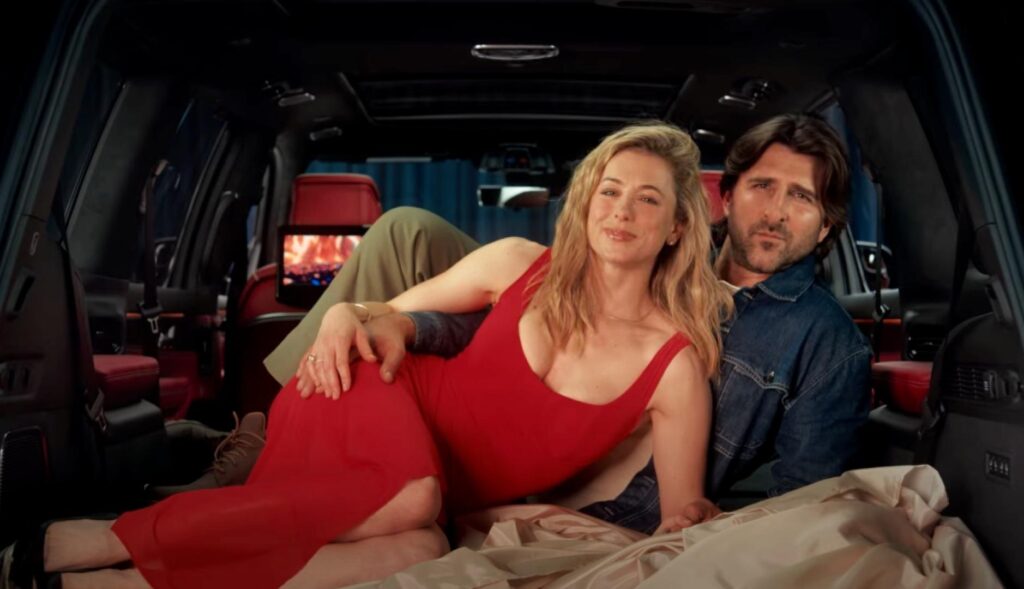 Una pareja tumbada dentro del maletero del coche abrazándose en pose sexy