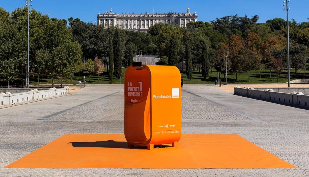 Una cabina naranja frente al Palacio Real de Madrid