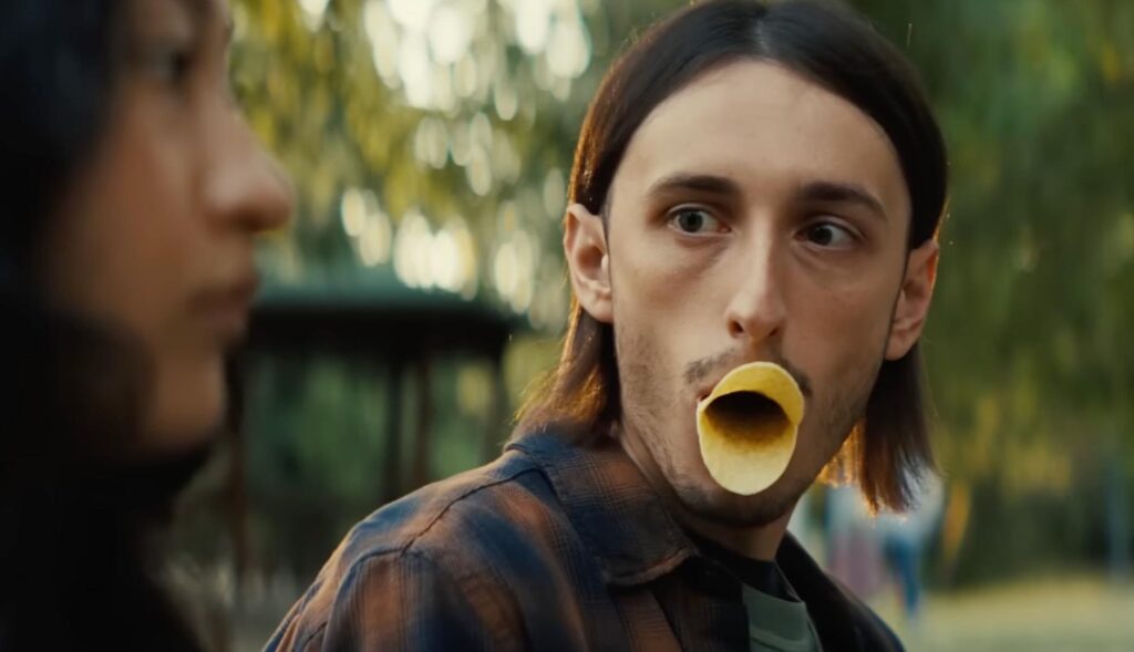 Un chico con patatas Pringles en la boca