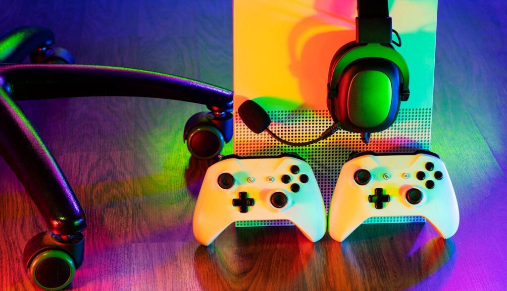 Dos mandos de Xbox en el suelo junto a la videoconsola