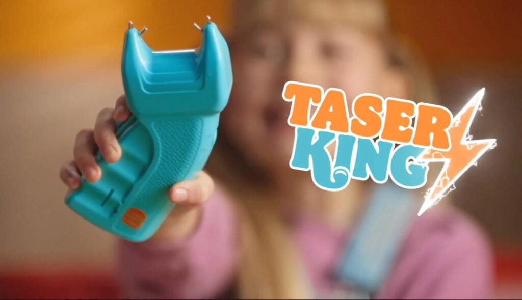 Una niña empuñando el taser azul de juguete