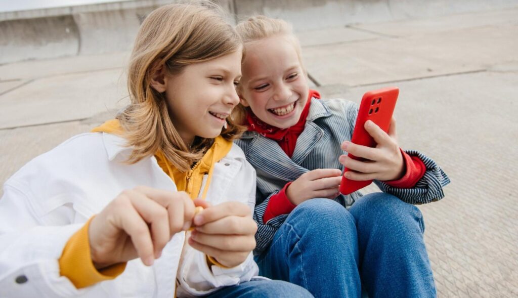 Dos niños mirando un smartphone sonriendo