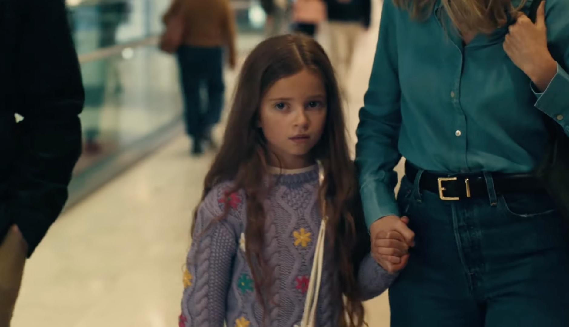 Una niña asustada coge la mano de su madre