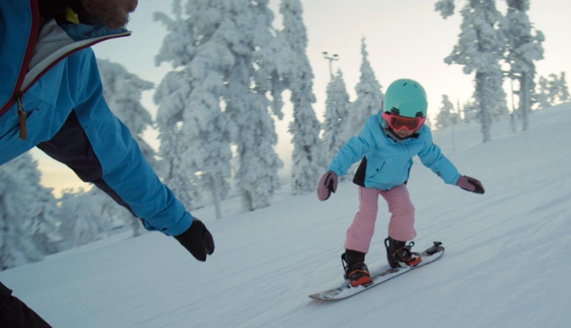 Una niña haciendo snowboard