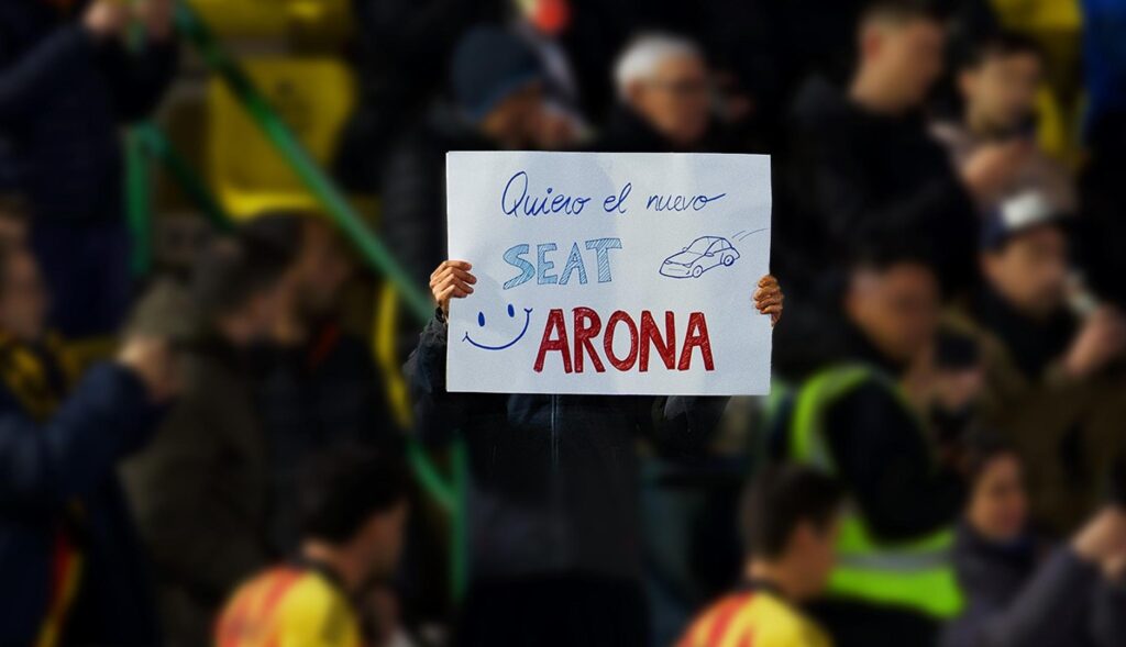 Persona sostiene una pancarta en un campo de fútbol