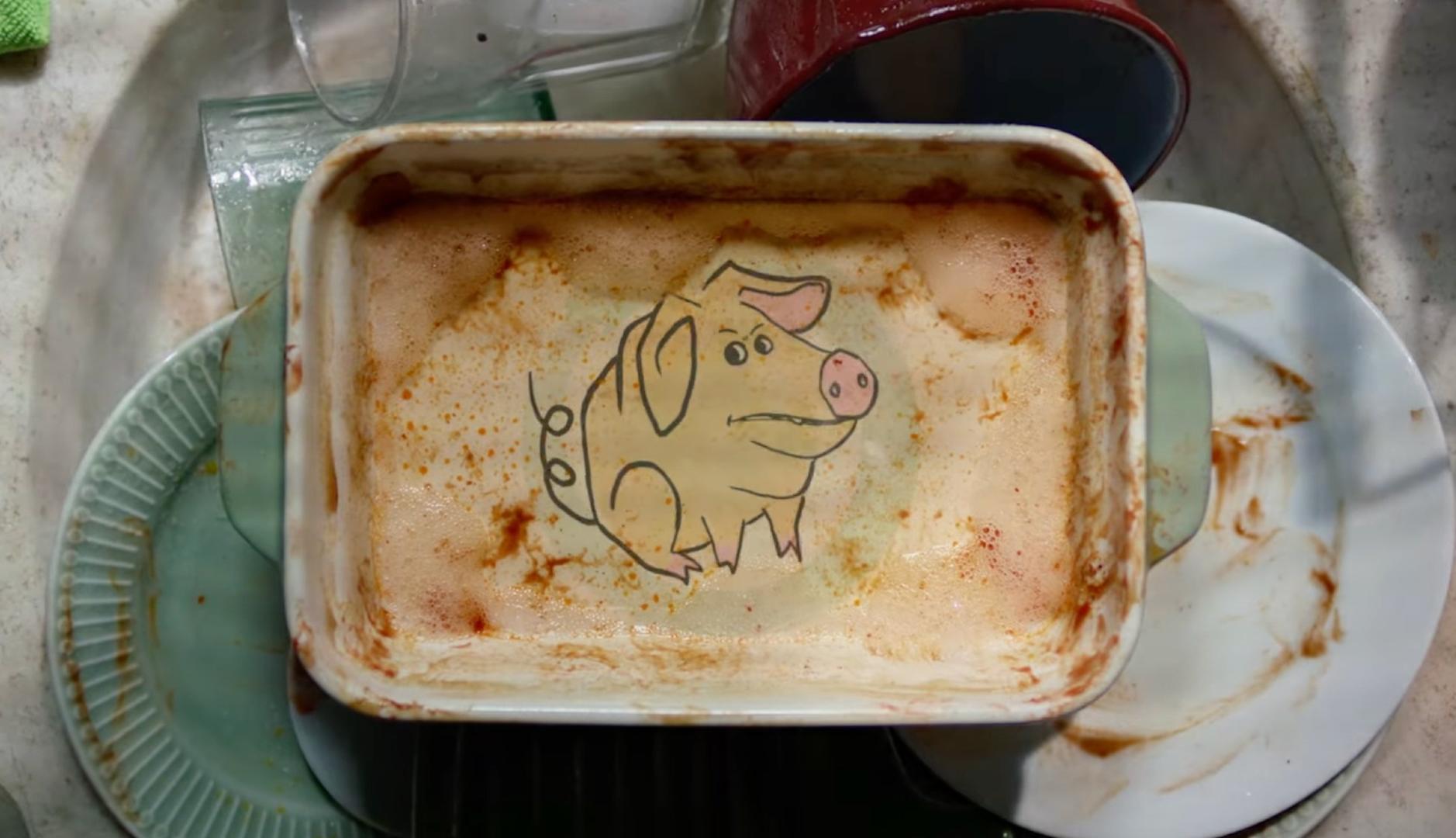 Fuente de cocina con un grabado de un cerdo a remojo en el fregadero