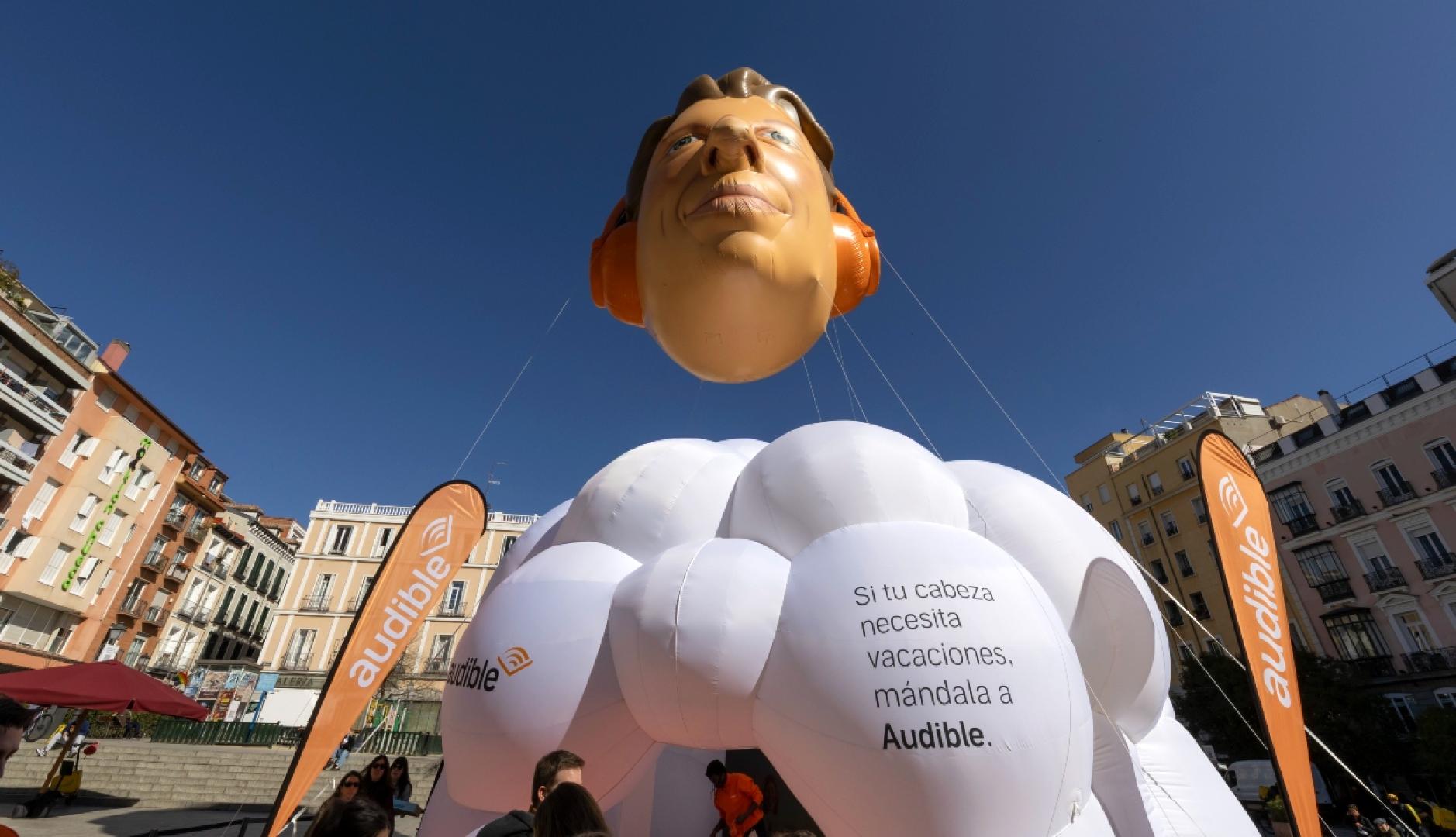 La instalación de Audible en forma de nube con una cabeza gigante flotando encima como un globo aerostático