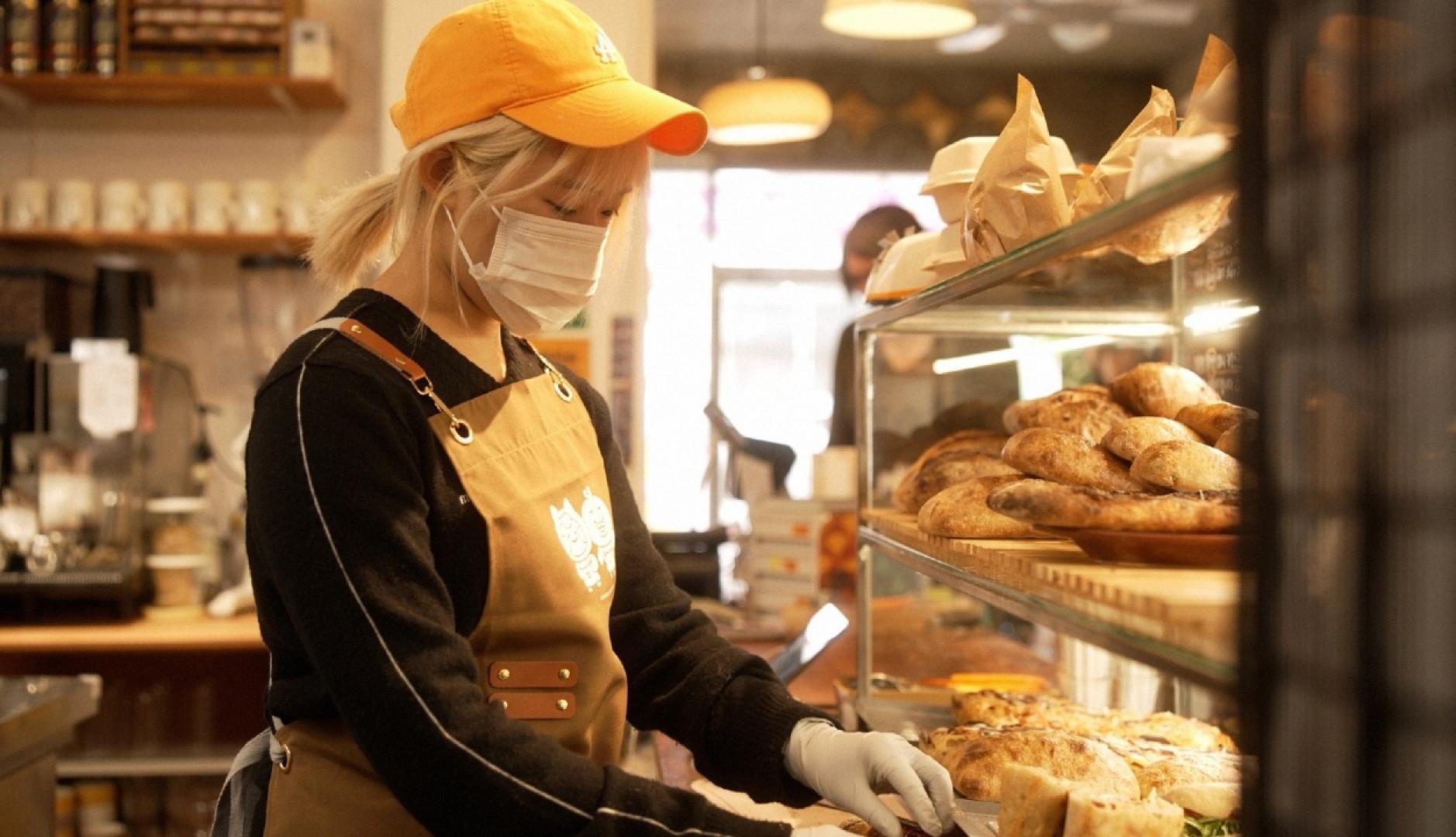 Una chica sirviendo en una panadería