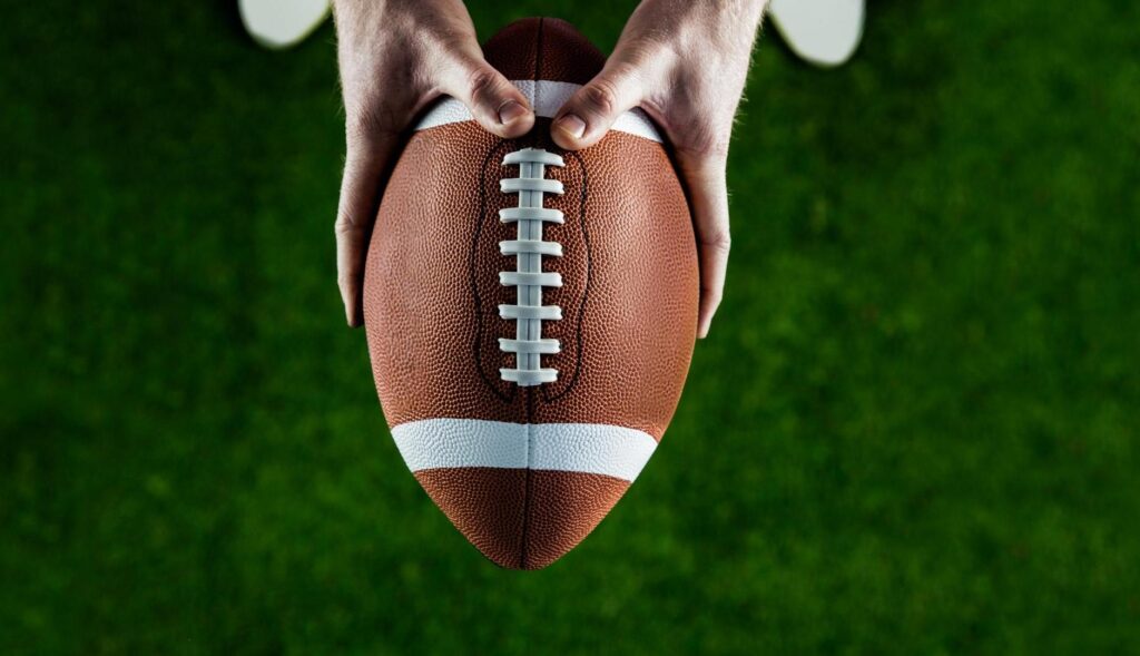 Manos sujetando un balón de rugby