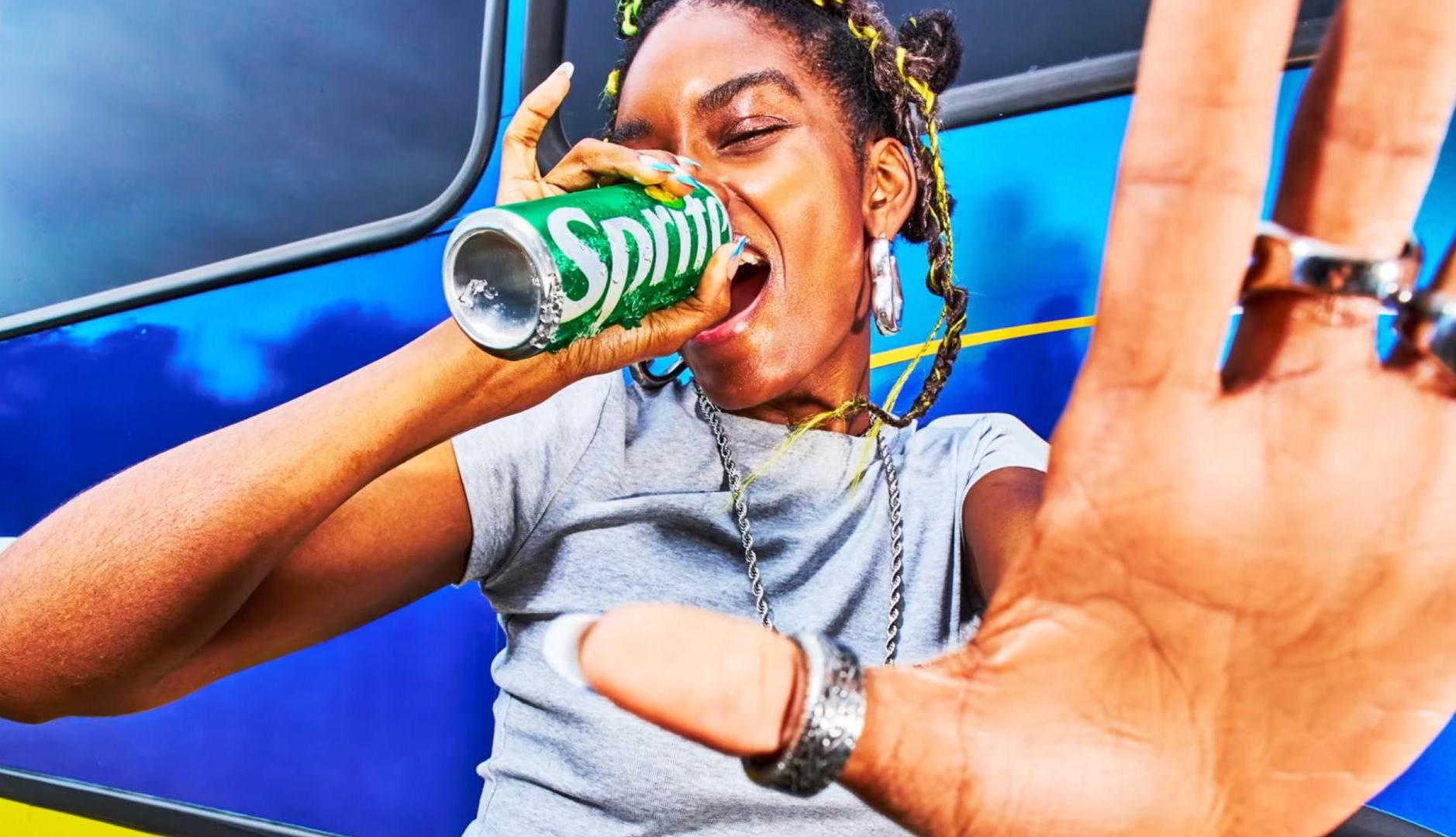 Chica bebiendo de una lata de Sprite