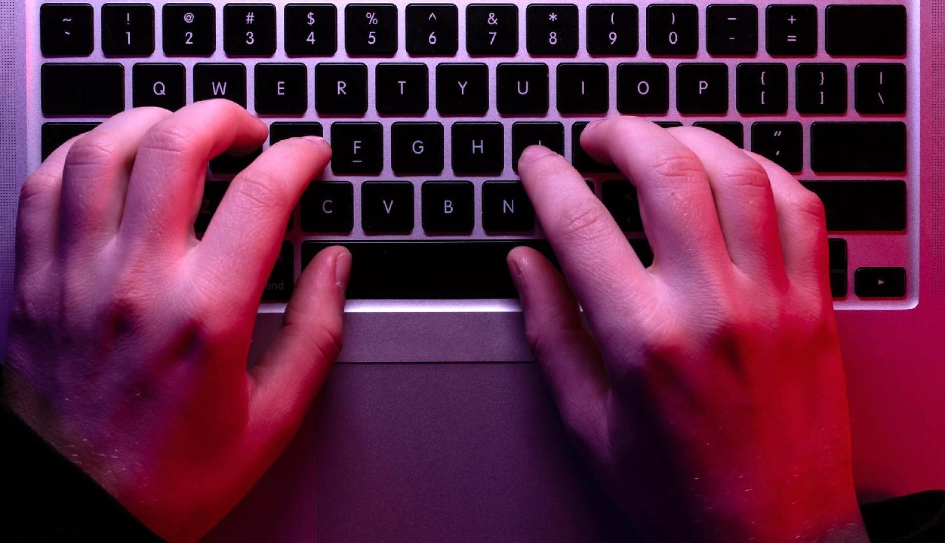 Una manos sobre el teclado de un ordenador portátil