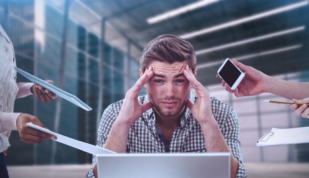 Un chico estresado rodeados de manos que le piden que haga tareas de trabajo