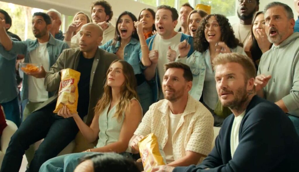 Alexia Putellas, Leo Messi y David Beckham en un salón rodeados de gente viendo el fútbol