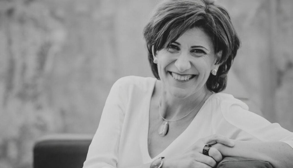 Foto en blanco y negro de Sara Blázquez sonriendo sentada en una butaca