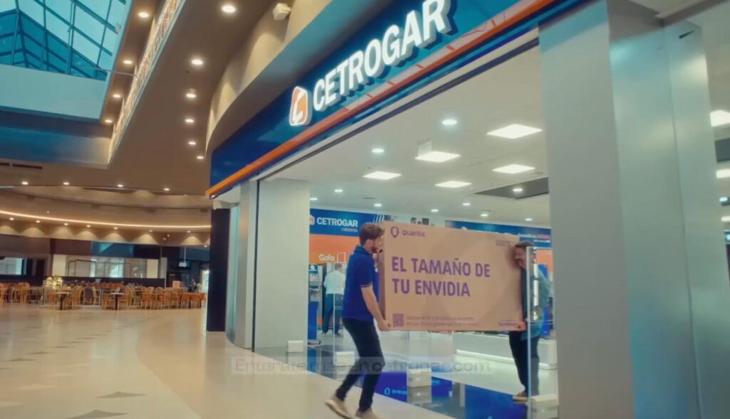Dos personas sujetan la caja de un televisor saliendo de una tienda de Cetrogar