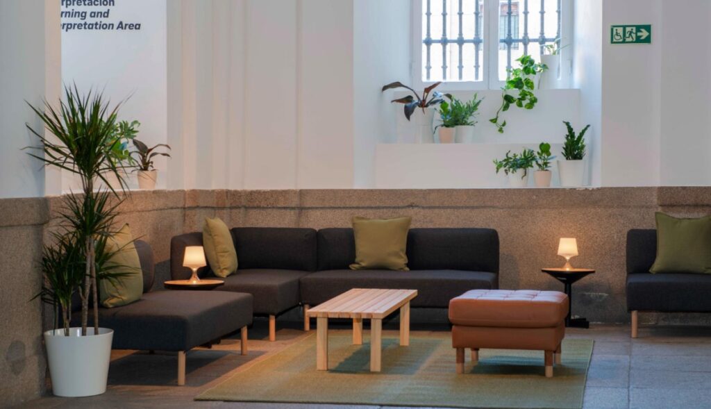 Un espacio común del museo con sillones y mesas de Ikea