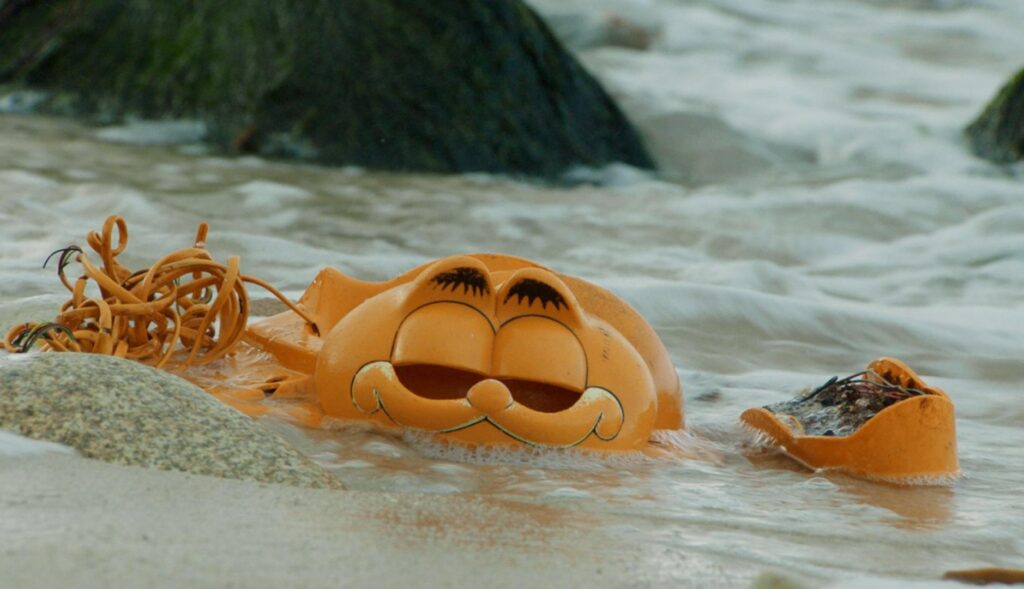Partes de un teléfono con forma de Garfield en la playa