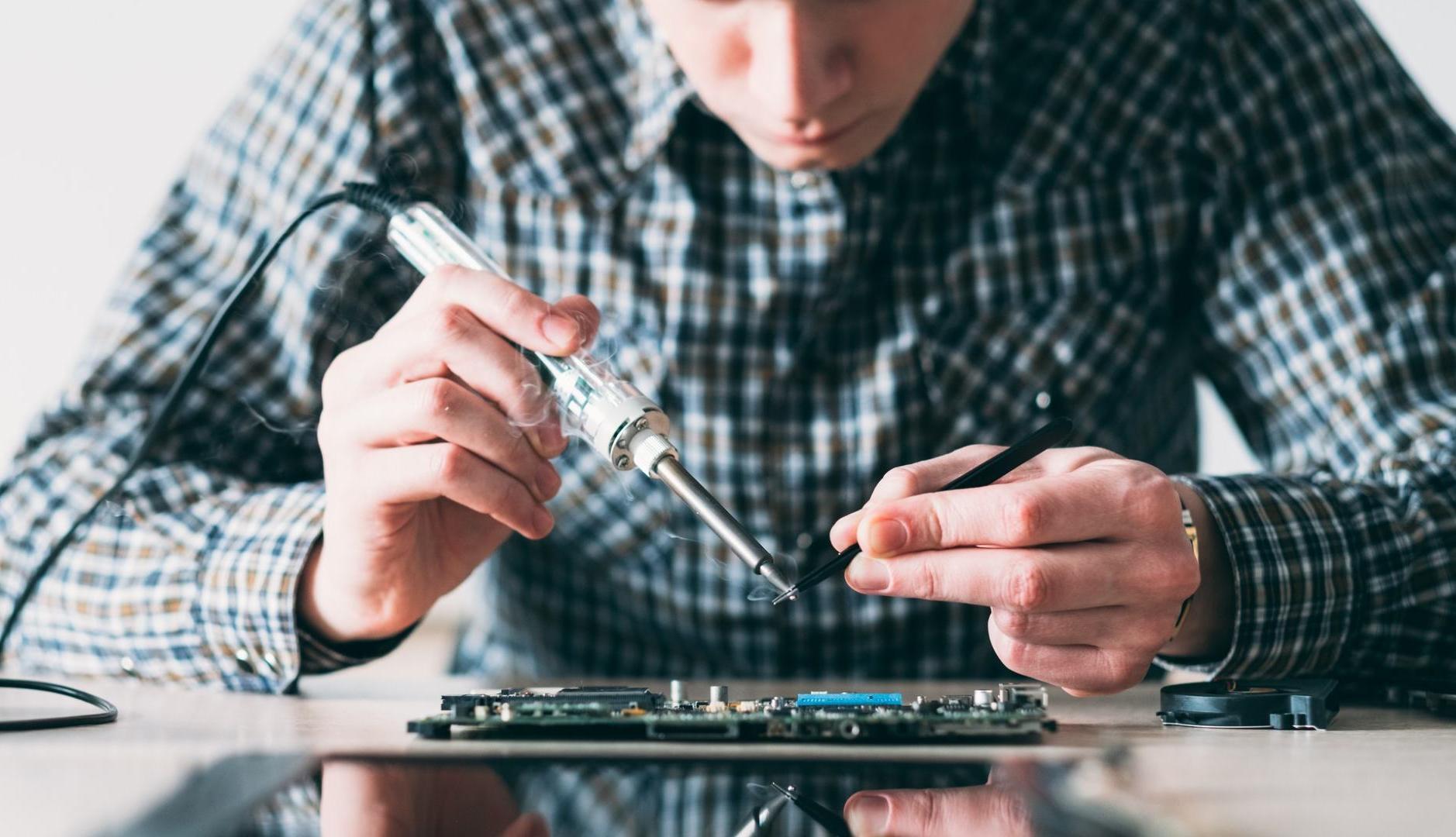 Joven reparando un teléfono