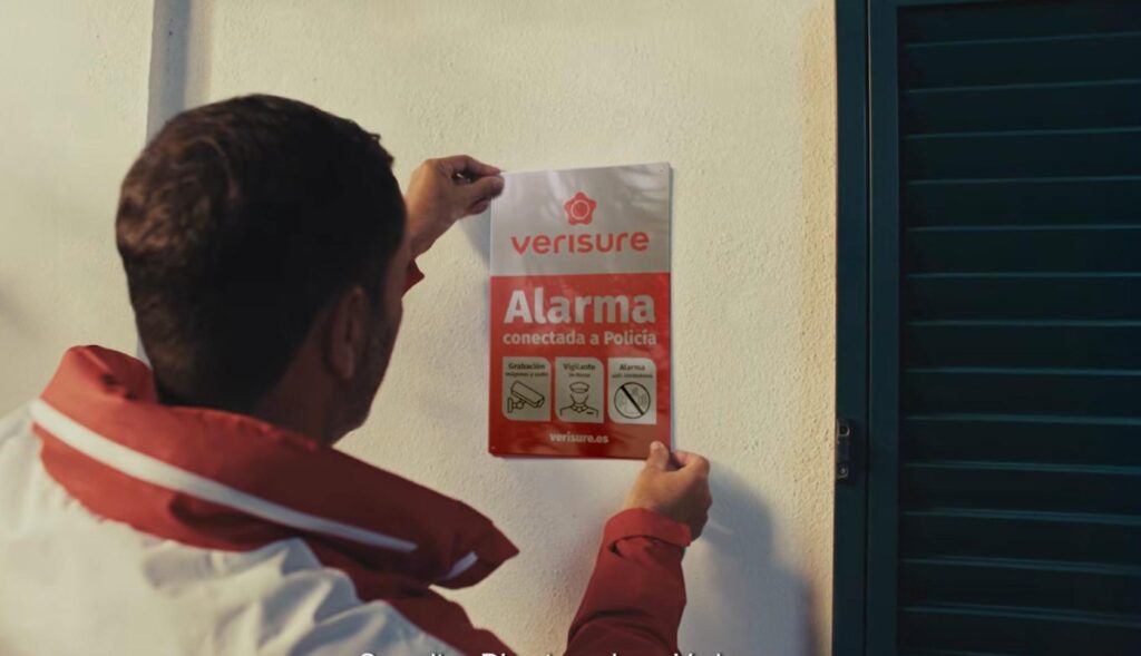 Hombre colgando un cartel de Verisure