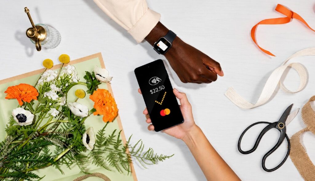 Una mano pagando con el teléfono a través de Mastercard