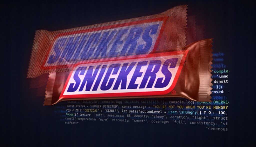 Una barra de chocolatina Snickers sobre un fondo de código de programación